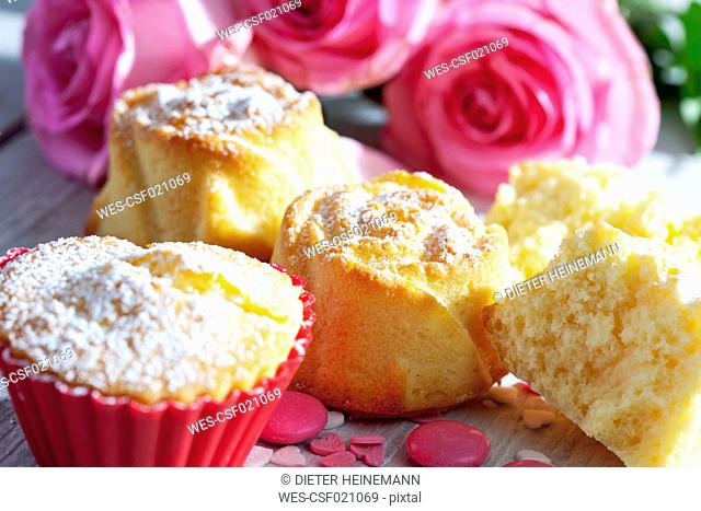 Muffins and pink roses on table