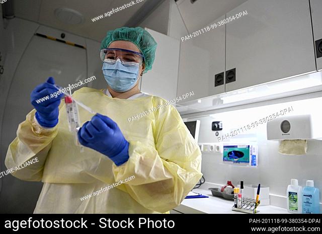 16 November 2020, Berlin: Carolyn Krause, study assistant, holds a tube with the swab for the PCR in her hand. For the coronavirus antibody study...