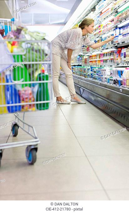 Woman examining products in grocery store