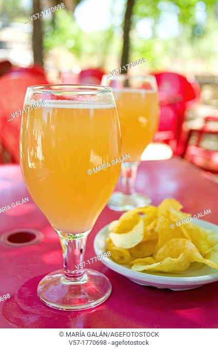 Spanish aperitif: two glasses of clara beer with lemon and chips in a terrace. Spain