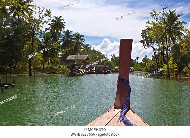 a traditional boat on river approaching a village, Thailand, Koh Phra Thong