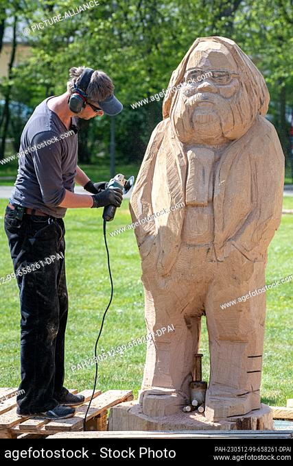 11 May 2023, Mecklenburg-Western Pomerania, Zinnowitz: Tim Weigelt, wood sculptor makes a wooden sculpture of Wolfgang Bordel