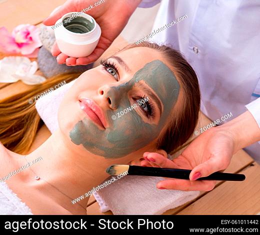 The young woman in spa health concept with face mask