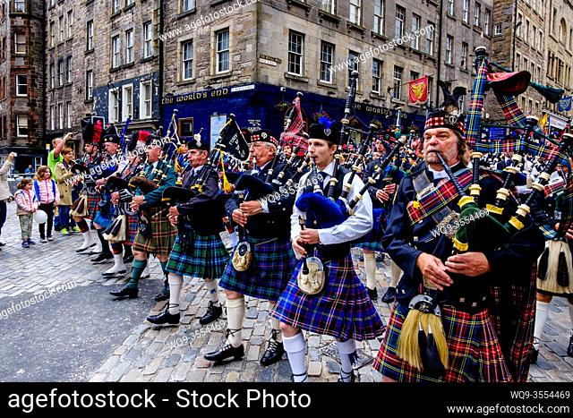 Massed pipe bands marching down the Royal Mile in Edinburgh, Scotland during the Fringe Festival in August