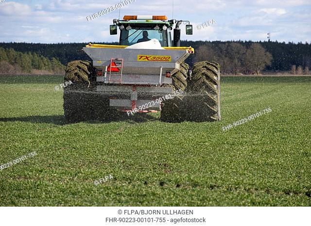John Deere 8530 tractor with Bredal TX3500 spreader, spreading granular fertilizer on arable field, Tierp, Uppsala County, Uppland, Sweden, april