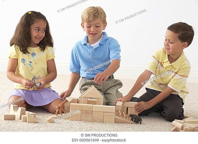three children building noah's ark with wooden blocks