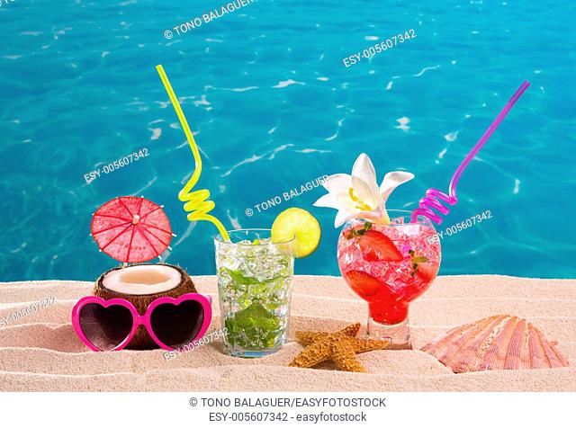 Mojito and strawberry cocktails on white sand beach and turquoise sea