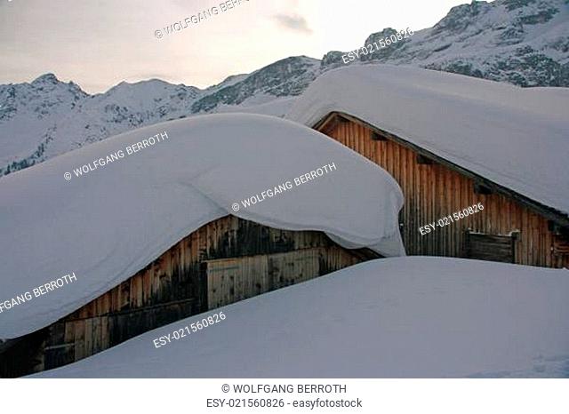 eingeschneite Hütten mit Schneemassen auf dem Dach