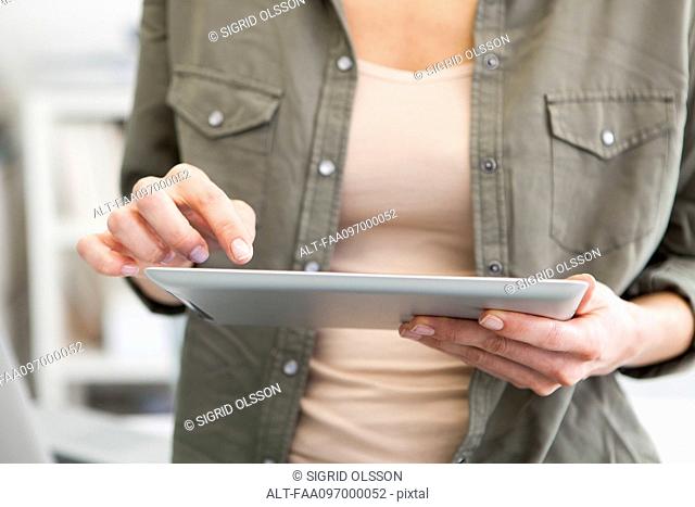 Woman using digital tablet, cropped