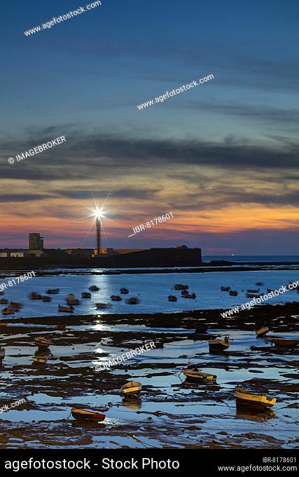 Lighthouse, Faro del Castillo de San Sebastián, fishing boats, sunset, low tide, Cadiz city, Costa de la Luz, Cadiz, Andalucia, Spain, Europe