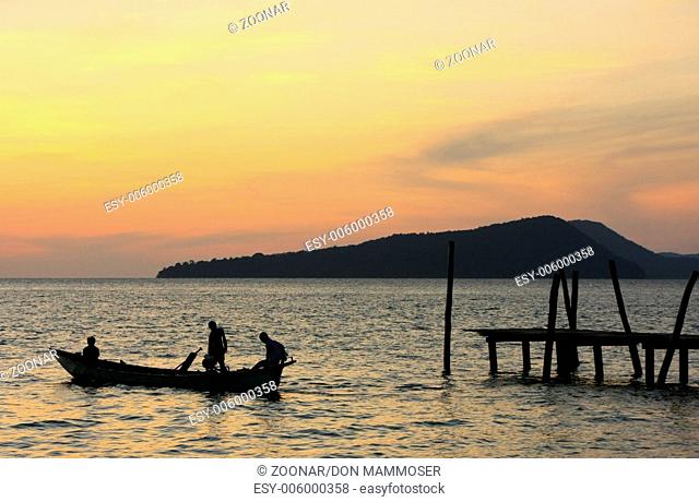 Silhouette of traditional fishing boat at sunrise