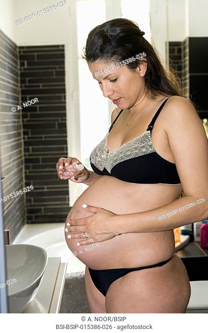 Reportage on Maureen during her second pregnancy. 7th month of pregnancy. Maureen massages her stomach with body oil to avoid stretch marks