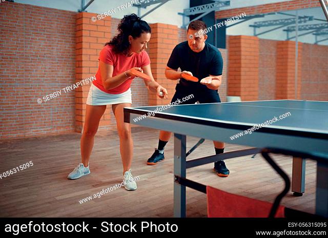 Man and woman on table tennis training, ping pong players. Couple playing table-tennis indoors, sport game with racket and ball, active healthy lifestyle