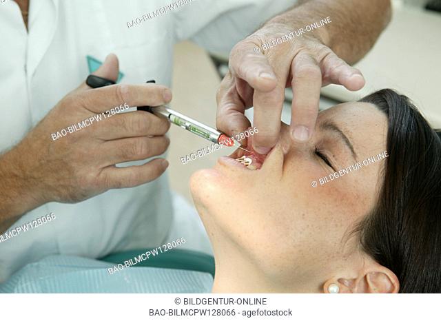 Woman gets a syringe with the dentist