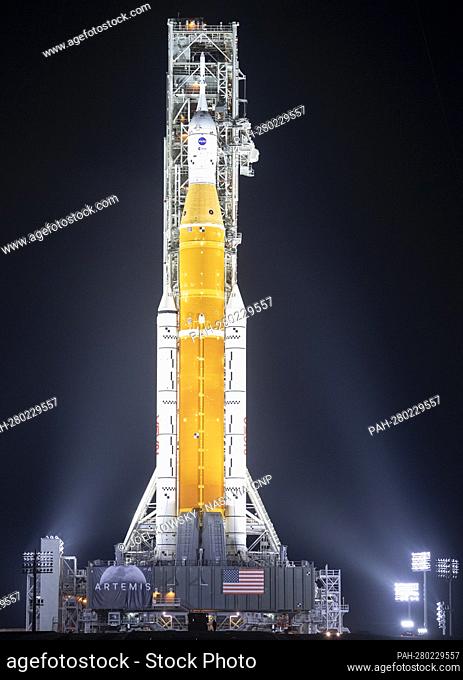 NASA’s Space Launch System (SLS) rocket with the Orion spacecraft aboard is seen illuminated by spotlights atop a mobile launcher at Launch Complex 39B, Friday
