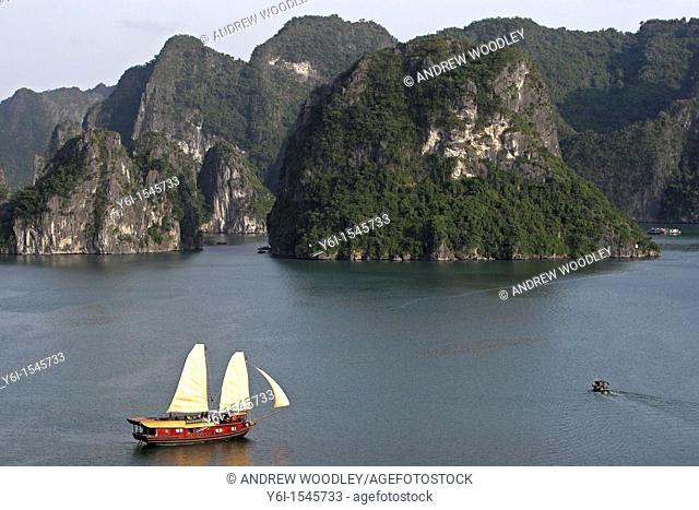 Cruising junk with sails hoisted Halong Bay Vietnam