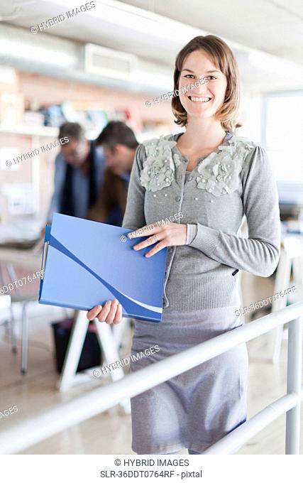 Businesswoman carrying folder in office