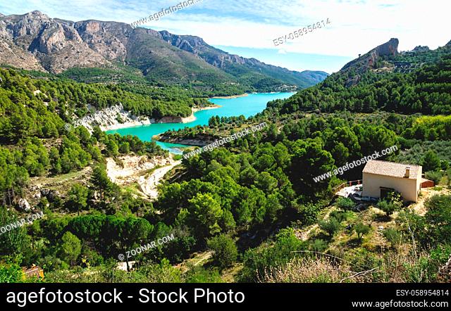 Turquoise colored dam reserevoir lake surrounded by green forest of Guadalest, Costa Blanca, Spain