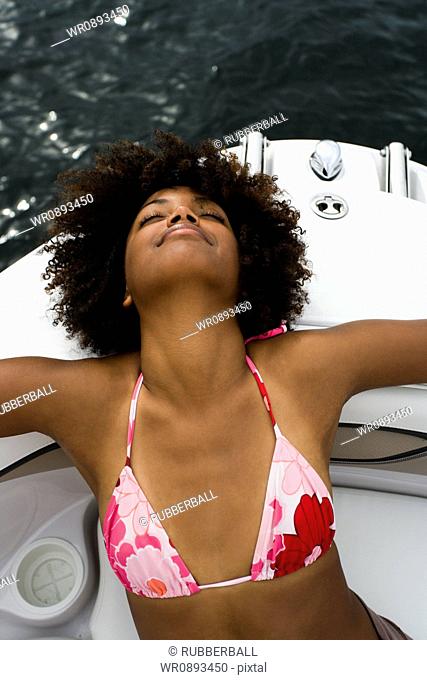 High angle view of a young woman resting on a speed boat
