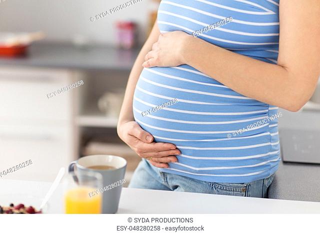 close up of pregnant woman touching her belly