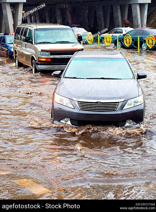 Car traffic in a heavy rain on a flooded city road