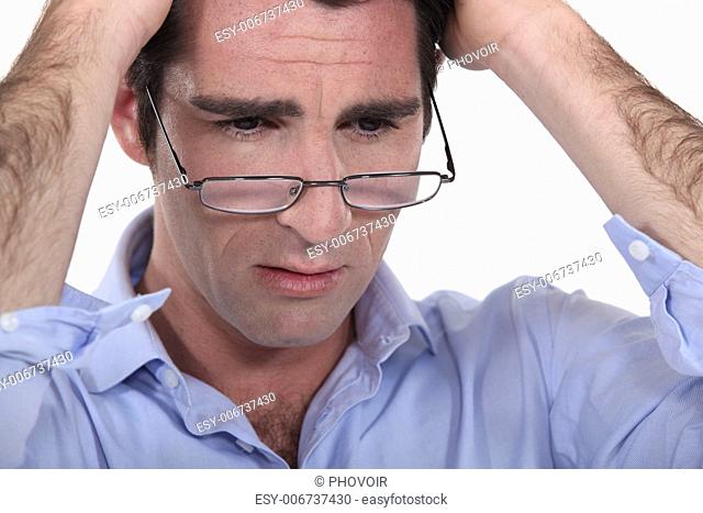 man with glasses lowered on his nose looking annoyed