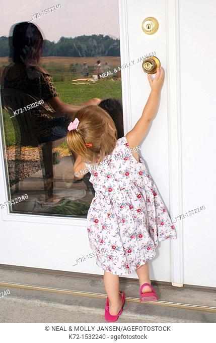 Unsupervised child tries to open a door