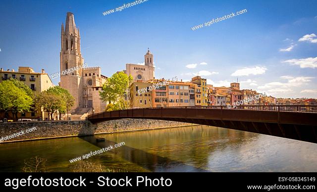 Sant Feliu bridge and Sant Feliu church in Girona, Catalonia, Spain. Colorful houses near the river. Long shutterspeed shot