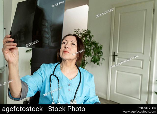 Mature doctor examining X-ray at medical practice