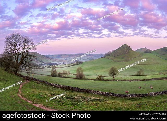 The distinctive Parkhouse Hill in Glutton Dale with stunning morning light catching the clouds above in the Peak District National Park, Derbyshire