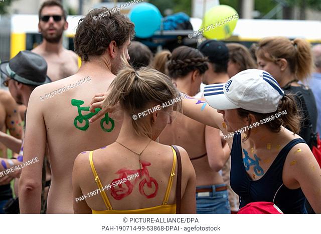 14 July 2019, Berlin: Demonstrators paint themselves during the body painting at the protest action ""2nd Berlin Bikini and Swimsuit Bicycle Ride""