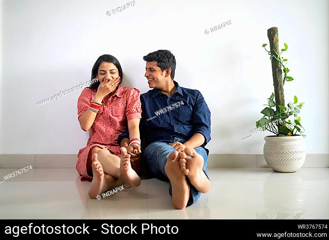 Young newlyweds sitting together and talking in their apartment