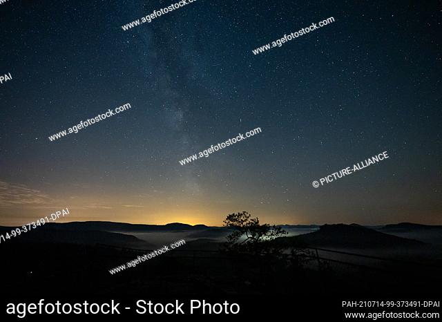 PRODUCTION - 10 July 2021, Rhineland-Palatinate, Vorderweidenthal: Stars with the Milky Way stand above the Palatinate Forest