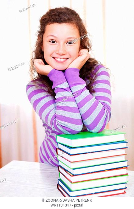 Little girl with pile of books