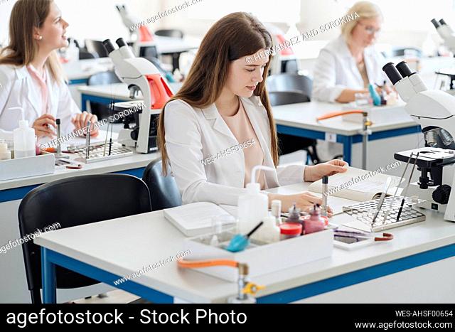 Young female researcher working in science class