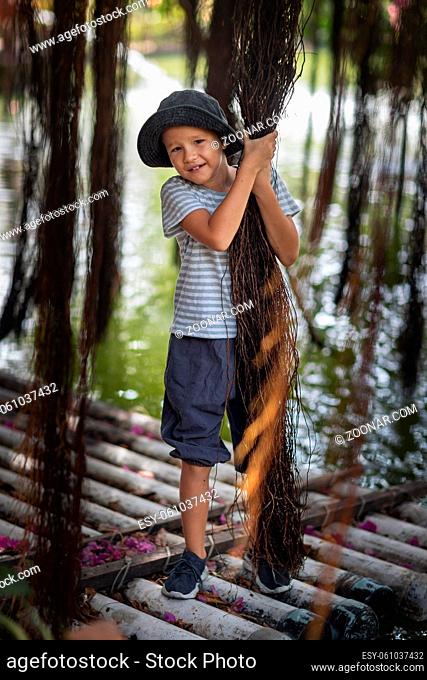 Boy having fun on the lake with banyan tree