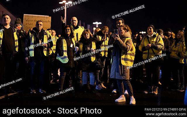 12 December 2023, North Rhine-Westphalia, Cologne: Strikers from UPS and Fedex stand in a parking lot at Cologne/Bonn Airport during a warning strike