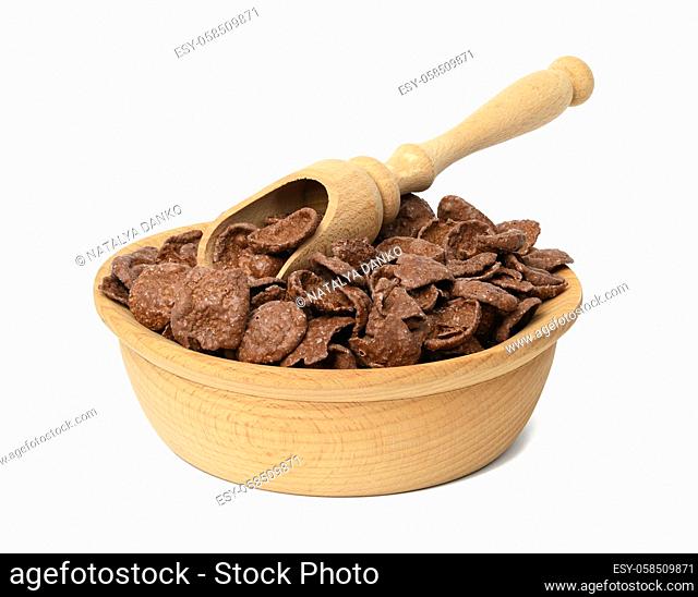 chocolate cornflakes in wooden plate isolated on white background, dry morning breakfast