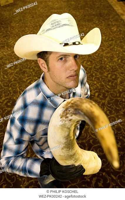 USA, Texas, Dallas, Young man wearing cowboy hat, holding horns, elevated view