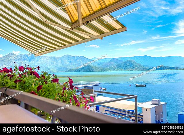 Terrace of cafe on Scadar lake near dock with touristic boats