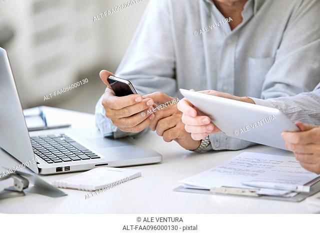 Men using wireless devices, cropped
