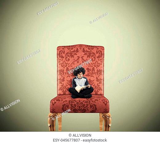Teenager reading a book on a huge chair