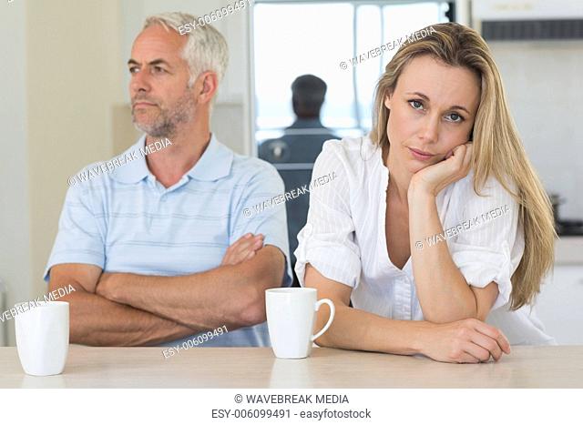 Fed up woman sitting at the counter with her partner