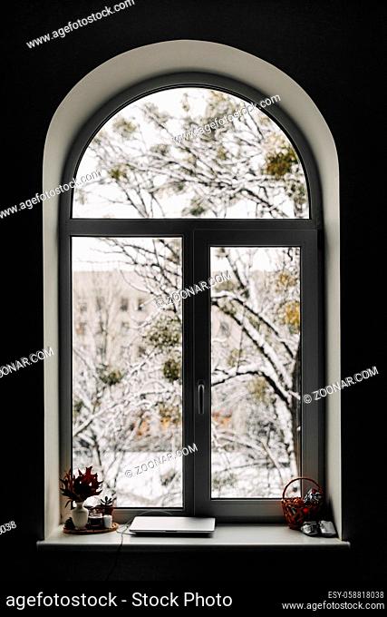 View through arch window on snowy scene. Christmas at home. High quality photo