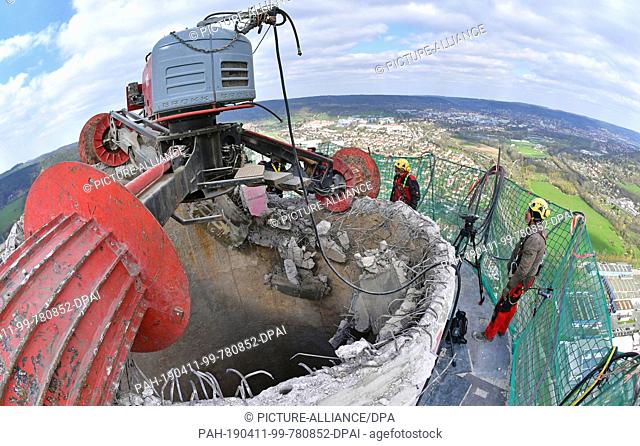 11 April 2019, Thuringia, Jena: Steffen Hartmann (l-r) and Olav Jahn, demolition specialists, observe the demolition of the chimney of the TEAG heating power...