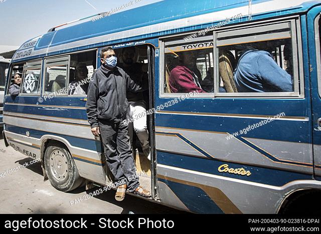 03 April 2020, Egypt, Shubra Al Khaymah: A man is seen wearing a face mask as he rides a public transportation minibus amid the Coronavirus (Covid-19) outbreak