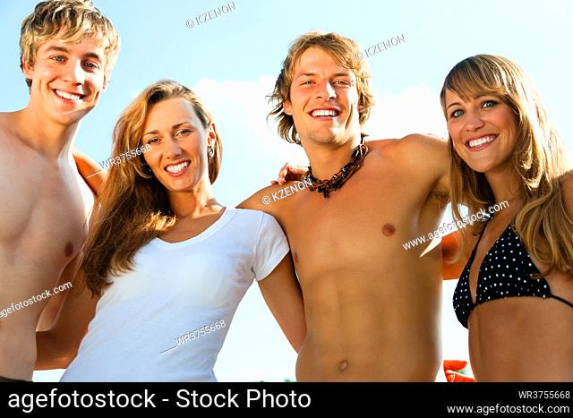 Group of four very beautiful people - men and women - on the beach
