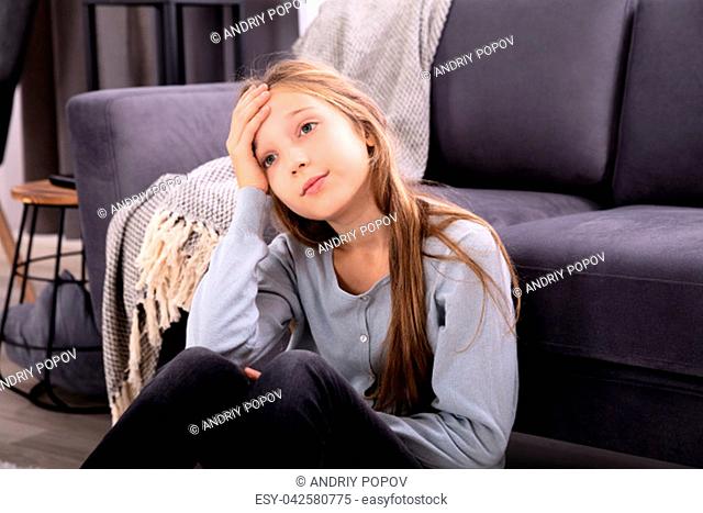 Close-up Of A Depressed Girl Sitting In Front Of Sofa