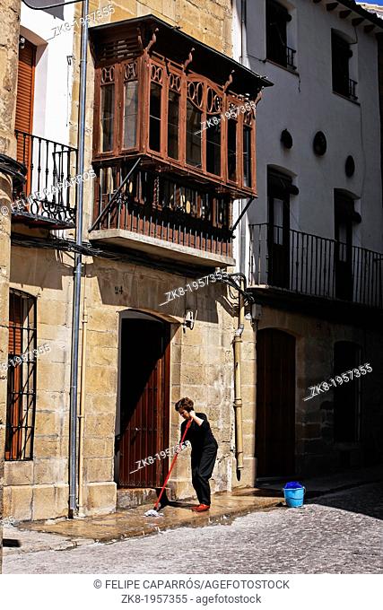 House and traditional balcony in òbeda, woman cleaning the entrance on a sunny day, òbeda, JaŽn province, Andalusia, Spain