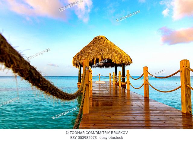 hot tropical day the Caribbean sea pier with pergola palm leaves
